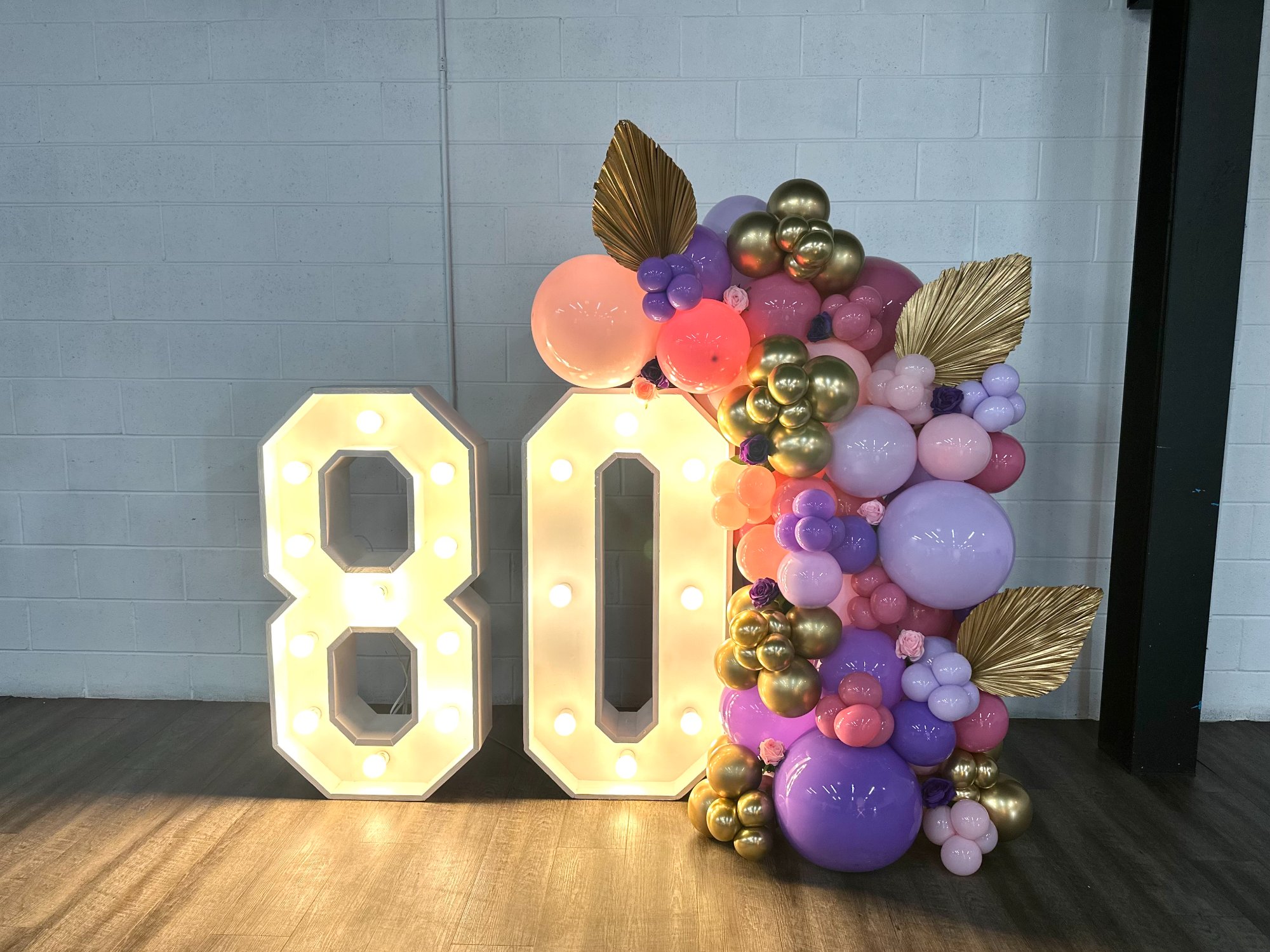 Purple gold balloon arrangement with marquee 80 milestone birthday